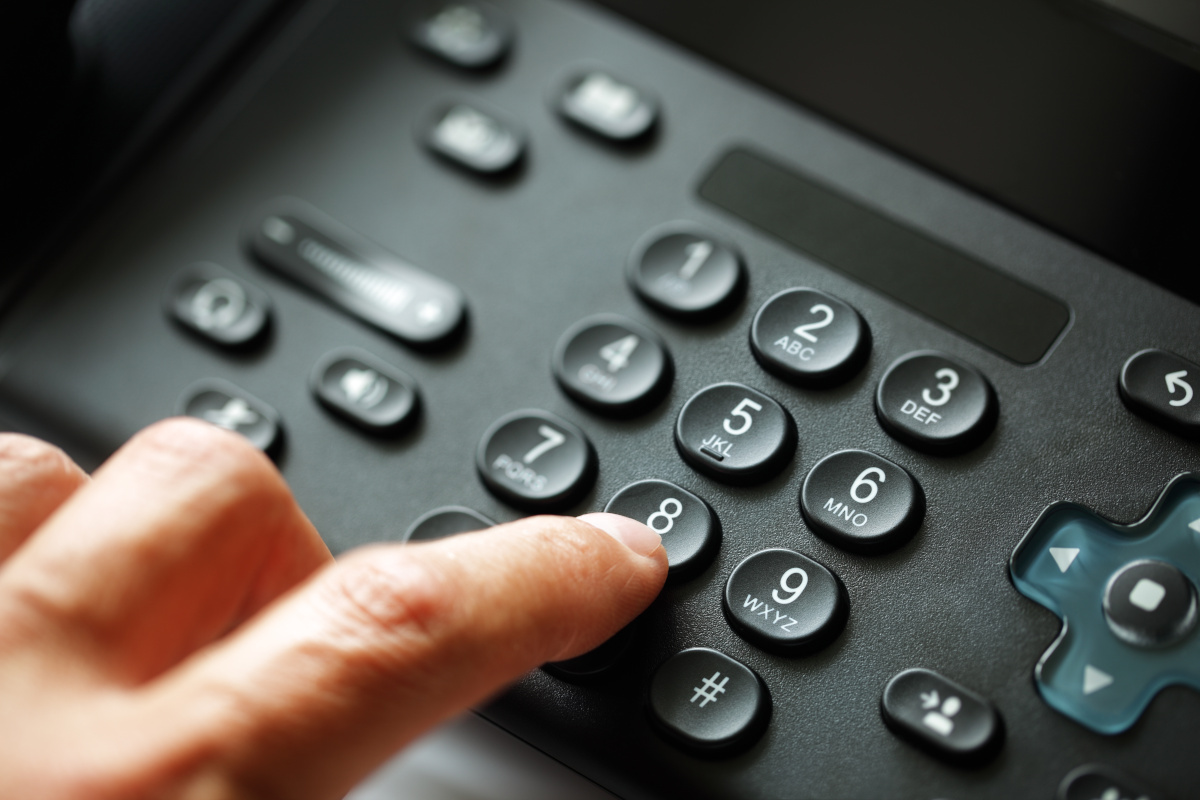 A person dialing on a business phone