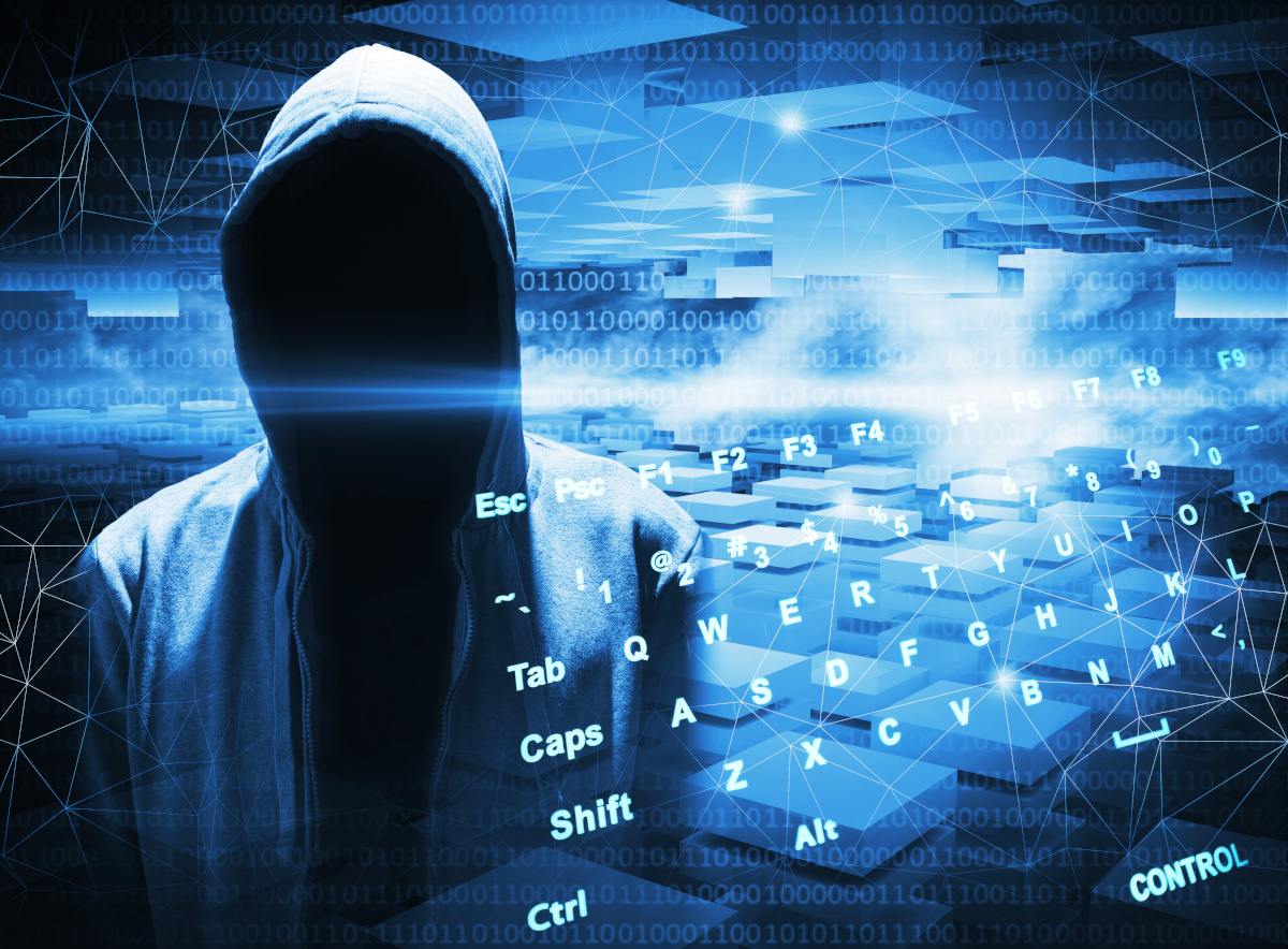 A shadowed hacker wearing a hooded sweatshirt