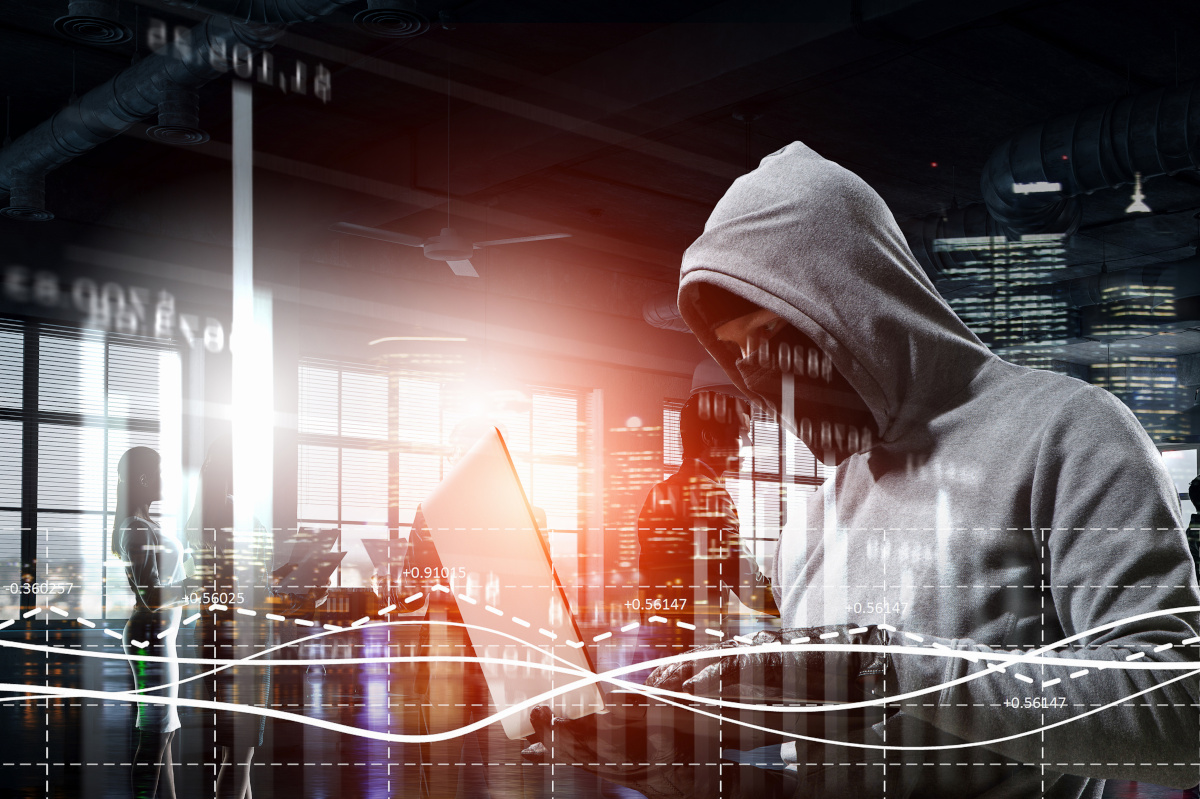 A hacker in a hoodie stealing information